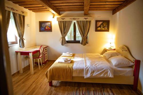 ŞinteuDue Fratelli Village Resort的卧室配有一张床、一张书桌和窗户。