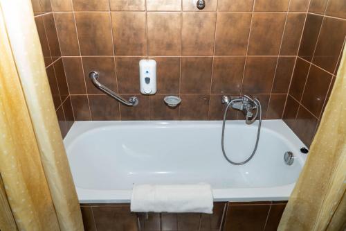赫维兹马耶里克酒店的带浴缸的浴室和墙上的电话