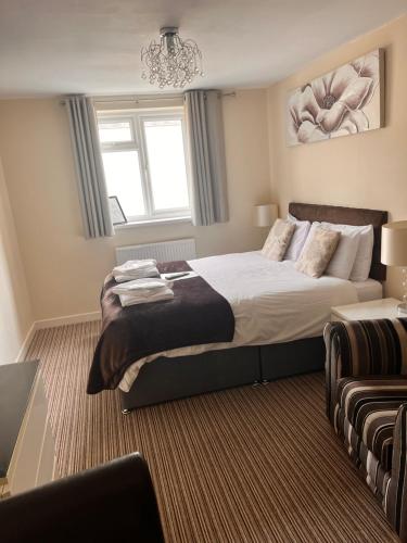 布莱克浦The Oxfordshire的一间卧室配有一张大床和一个吊灯。