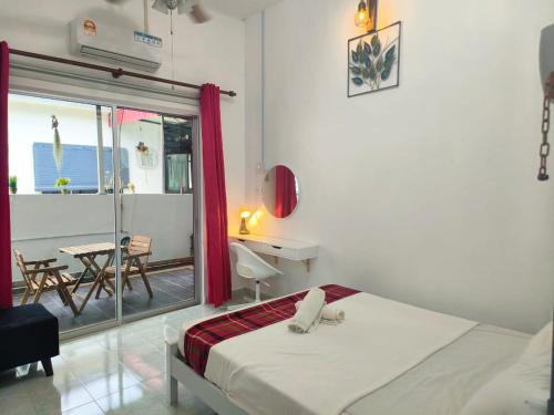 太平Taiping Vacation Home的一间卧室配有一张床、一张桌子和一个窗户。