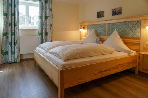 里姆斯廷格Fürstnerhof Chiemsee的一间卧室配有一张木架大床