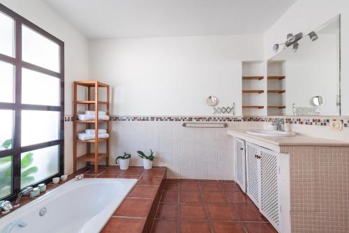 巴尔塞基略Home2Book Villa El Naranjo, Garden & Pool的带浴缸、两个盥洗盆和窗户的浴室