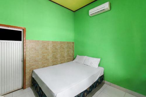 Labu SumbawaOYO 92908 Hotel Jayanni的绿色的小房间,设有床和绿色的墙壁