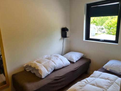兰讷斯Randers City Camp的客房设有两张床和窗户。