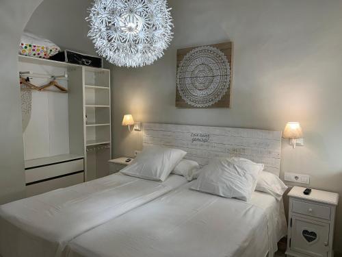 科尔多瓦Aljara Mezquita的卧室配有一张带吊灯的大型白色床。
