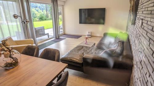 施莱登Ferienwohnung Julia Schleiden Eifel的客厅配有真皮沙发和桌子