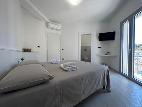 泰尔泰尼亚Domu Dina Affittacamere 3的白色的卧室设有床和大窗户