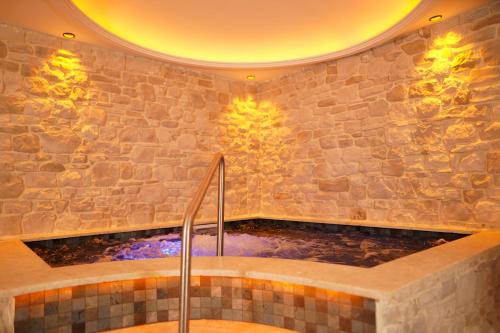 伊斯坦布尔Emirtimes Hotel&Spa - Tuzla的一间带石墙浴缸的浴室