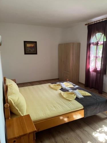 杜尼Hotel Gamartata的一间卧室配有一张带黄色床单的大床和窗户。