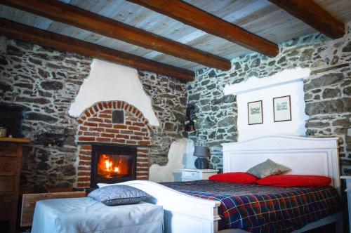 Inverso PinascaChalet in pietra e legno con caminetto的一间卧室配有一张床和一个砖砌壁炉