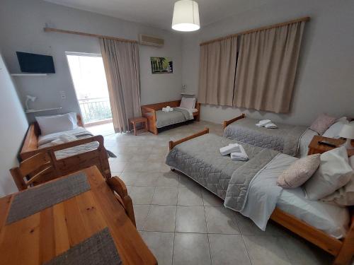 鲁维斯Zagas Hotel Ξενοδοχειο Ζάγκας的一间带两张床和一张沙发的客厅