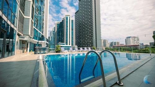 巴统New Wave Hotel的一座位于高楼城市的游泳池