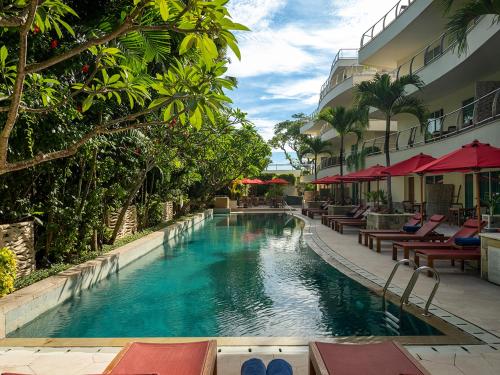 勒吉安Anantara Vacation Club Legian的酒店旁的游泳池配有桌椅