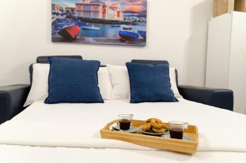 巴里Modern Stone Apartment in the Heart of Bari的床上的托盘食物和两杯咖啡