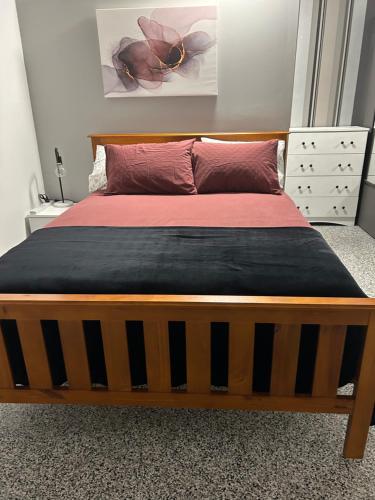 ClermontClermont Guest House - Pet friendly的一张带木制框架和红色床单的大床