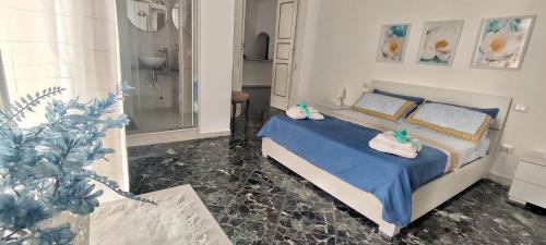 曼弗雷多尼亚Dimora della Marchesa - al Duomo的一间卧室配有一张带蓝色床单的床和淋浴。