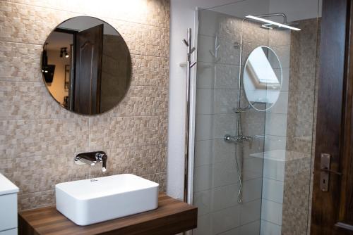 格奥尔盖尼The Home Sweet Home Studio Apartment的一间带水槽、镜子和淋浴的浴室