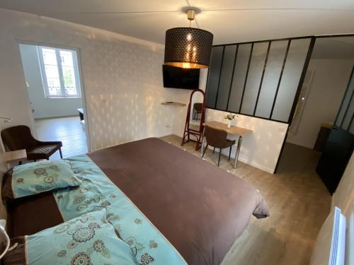 孔特雷克塞维尔Residence Gaby & Tom 4 Étoiles的一间卧室配有一张大床和一张桌子及椅子