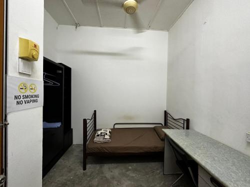 乌鲁地南Jiaxin Dormitory - Puteri Wangsa 家馨旅舍的小房间设有一张床和一张桌子