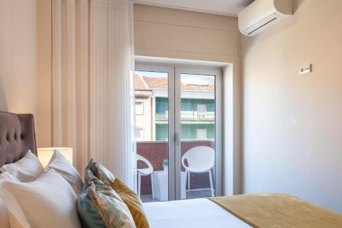 布拉加Liberdade Home Stay - Minho's Guest的一间卧室设有一张床和一个阳台的窗户。