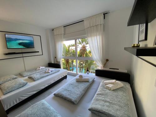 贝纳尔马德纳Modern Sea view Studio In Benal Beach的一间卧室设有两张床和大窗户