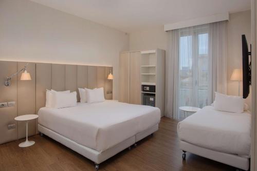 热那亚热那亚中心NH酒店的酒店客房设有两张床和窗户。