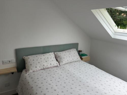 拉科萨Ático con vistas en Raxó的一间卧室配有一张带绿色床头板的床和窗户