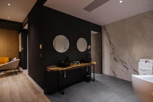 戈里察Park Plazza的浴室设有黑色墙壁和一张带三面镜子的桌子