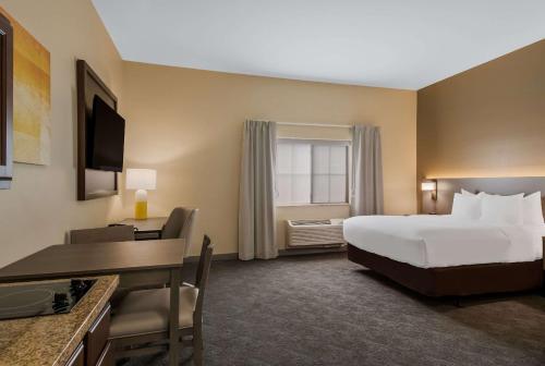 BarnesvilleComfort Inn & Suites Barnesville - Frackville的酒店客房设有一张床、一张桌子、一张床和一个窗户。