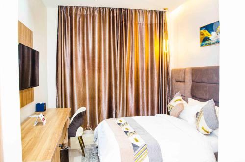 JiduOzinny Signatures Hotel的酒店客房,配有床、书桌和窗帘
