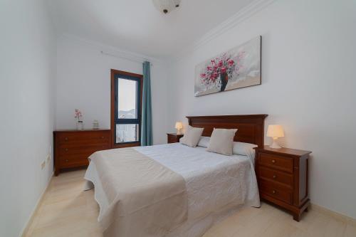 普拉亚布兰卡Mireya Apartment的白色卧室设有一张大床和镜子