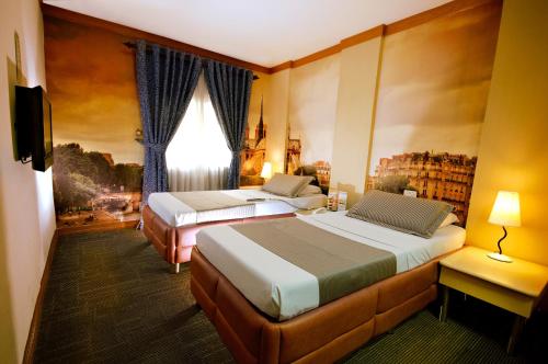 马尼拉亦优泰尔马卡迪酒店的酒店客房设有两张床和电视。
