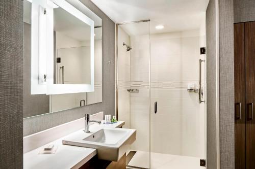 亨特斯维尔SpringHill Suites by Marriott Charlotte Huntersville的一间带水槽和淋浴的浴室