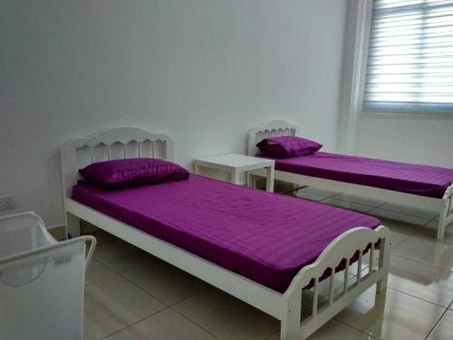 峇株巴辖HOMESTAY BATU PAHATKU- HOMESTAY IMAN的紫色床单的客房内的两张床