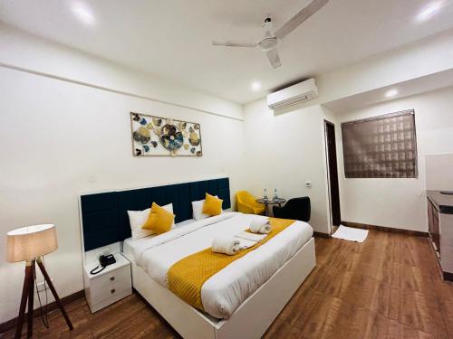 古尔冈Amahi Inn的一间卧室配有一张黄色和白色的大床