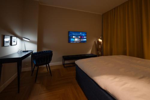 埃森Pssst ! Geheimtip in Rüttenscheid的酒店客房配有一张床、一张书桌和一台电视。