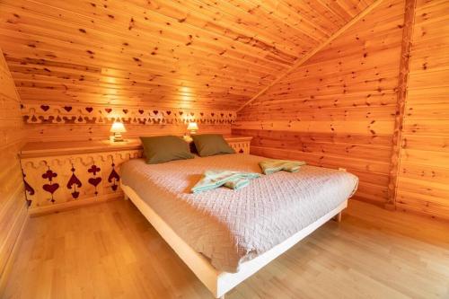 莱托利Le Chant du Ruisseau SPA - Sauna的小木屋内一间卧室,配有一张床