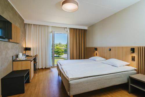 派尔努Hestia Hotel Strand的一间卧室设有一张大床和一个大窗户