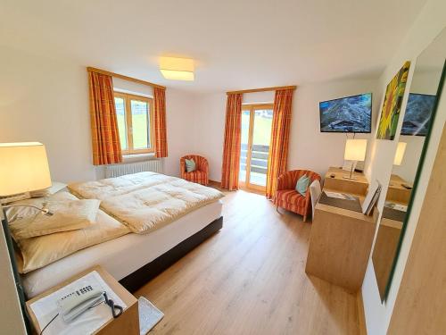 莱赫阿尔贝格Pension Mallaun的卧室配有一张床、一张桌子和椅子