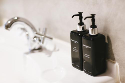 塞雷斯Cherry Blossom - Backup Power Inverter的浴室水槽上放两个黑肥皂瓶