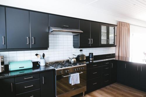 塞雷斯Cherry Blossom - Backup Power Inverter的厨房配有黑色橱柜和炉灶烤箱。
