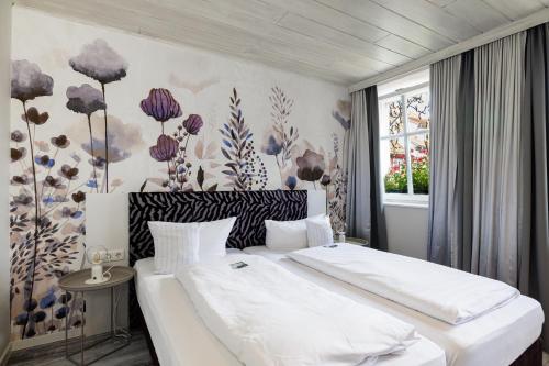 巴特温茨海姆祖姆斯托申弗莱尔酒店的一间卧室设有两张床和花卉墙