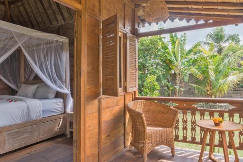 坎古Nunu Bali Eco Friendly Retreat的一间卧室,阳台上配有一张床和一张桌子