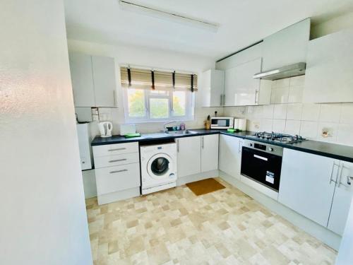 The HydeWonderful Apartment in London的厨房配有白色橱柜、洗衣机和烘干机