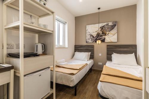 帕切维拉Studio apartment with twin beds & kitchenette at the new Olo living 24的小房间设有两张床和一个架子