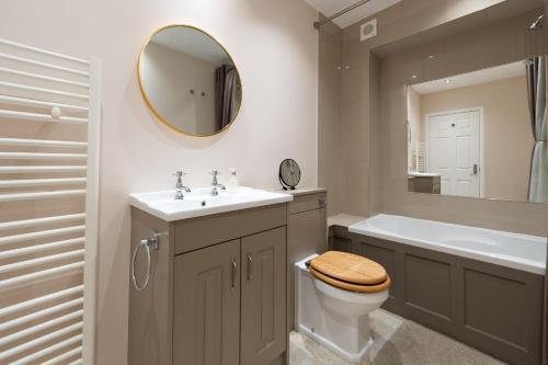 利特尔Tranquil 3BD Haven by the Sea in Littlehampton的一间带卫生间、水槽和镜子的浴室