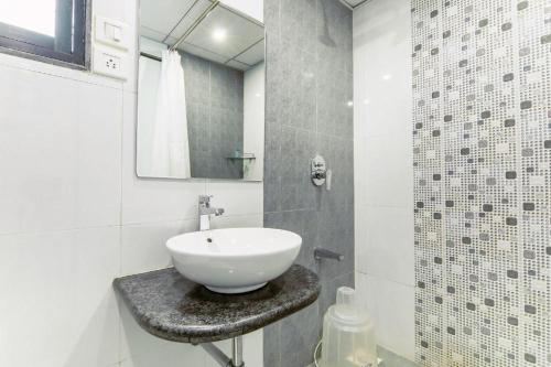 浦那Magnus Square Business Hotel的白色的浴室设有水槽和镜子