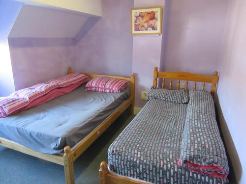伯明翰RK Heritage House的紫色墙壁客房的两张床