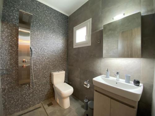 奥马斯帕纳吉亚斯Vot villas的浴室配有白色卫生间和盥洗盆。