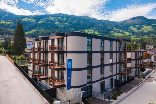菲根Zillertal Suites Fügen by ALPS RESORTS的公寓大楼设有阳台,后方是山脉